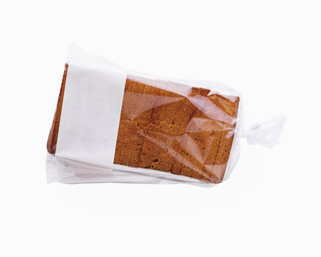 Clear plastic bag containing slices of fresh brown bread, isolated on a white backgroundの写真素材