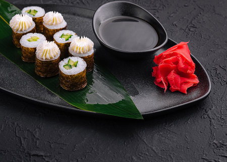 Gourmet sushi set on a black plate with soy sauce, wasabi, and pickled gingerの写真素材