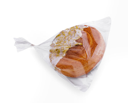 Loaf of fresh bread sealed in a clear plastic bag, isolated on a white backgroundの写真素材