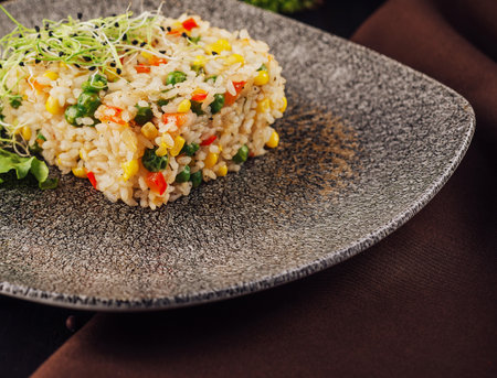 Bowl of rice with peas, corn and red peppers close upの写真素材