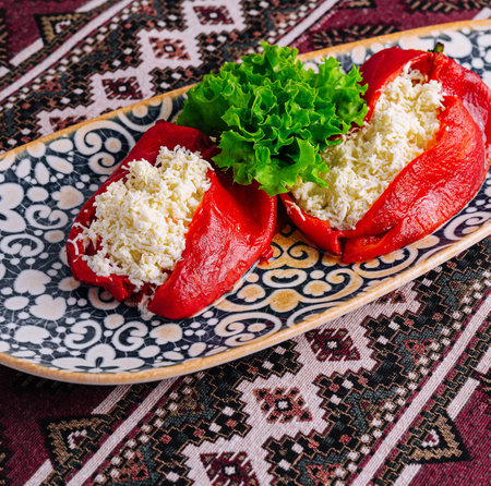 Delicious red peppers filled with cheese on a patterned plate, traditional cuisine setupの写真素材