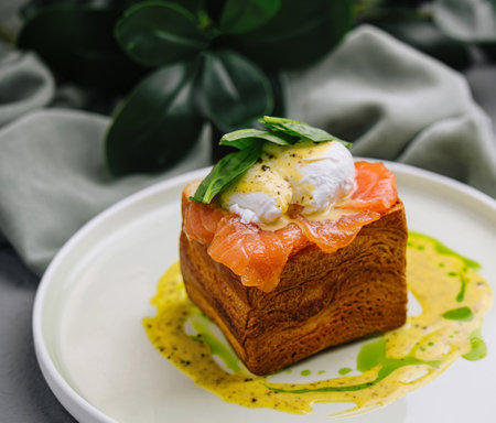Elegant dish of smoked salmon on brioche with poached egg and basil, ready for a fine dining...