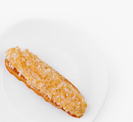 Top view of a delicious eclair pastry on a clean white plate with a white backgroundの写真素材