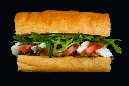 Delicious italian sandwich with arugula, tomatoes, and cheese on a crispy baguette
