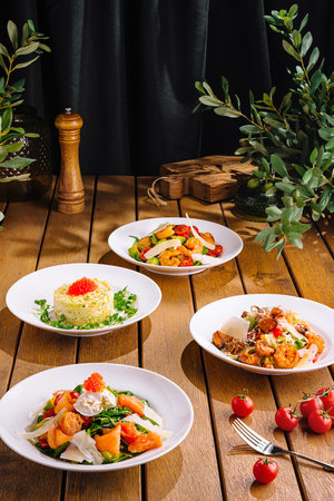 Elegant presentation of diverse gourmet meals in a rustic dining setupの写真素材