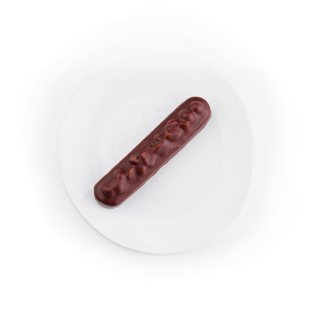 Top view of a delicious chocolate Eclair on a clean white plate, isolated on white background