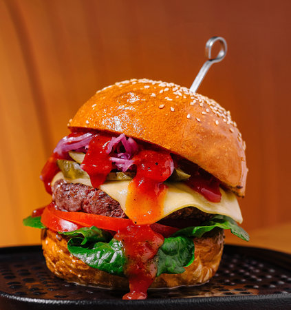 Artfully crafted gourmet burger with fresh toppings on a stylish tray, presented against a warm, modern backdropの写真素材