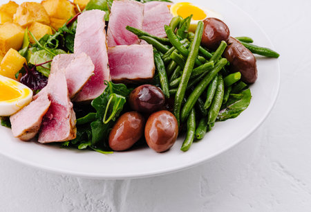 Vibrant and nutritious nicoise salad with seared tuna, greens, eggs, and potatoesの写真素材