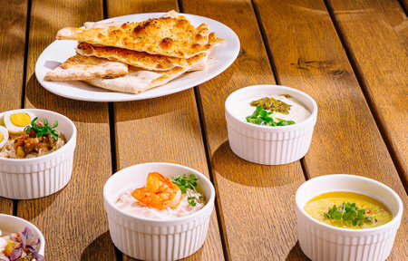 Spread of delicious mediterranean dishes artfully displayed on a warm wooden background