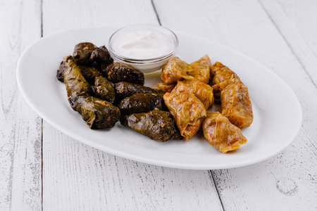 White plate with cabbage rolls stuffed with minced meat and rice seasoned with herbs and spices...