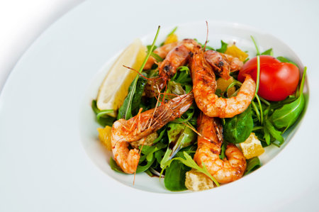 Fresh and healthy salad with grilled shrimps, arugula and orange slices, seasoned with balsamic sauceの写真素材