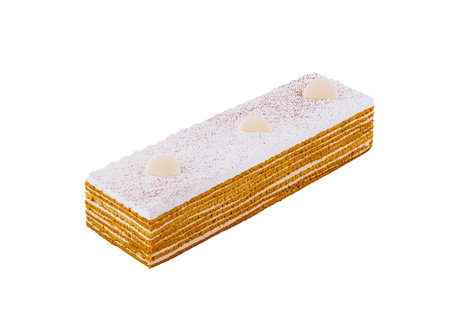 Delicious honey cake is covered with white cream on a white background