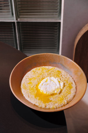 Modern restaurant is serving a classic italian comfort food, polenta with melted butter and cheeseの写真素材