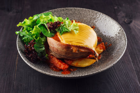 Chicken breast stuffed with cheese and bacon, served with salad and tomato sauce on gray plateの写真素材