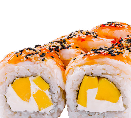 Uramaki sushi rolls with shrimp, mango, cream cheese and sesame seeds on top on white backgroundの写真素材