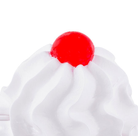 Single red cherry is sitting on top of a whipped cream dessertの写真素材