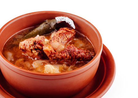 Aromatic soup with meat and potatoes is served in a clay bowl, providing a rustic and flavorful dining experienceの写真素材