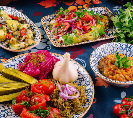 Plates with delicious food arranged on a table with a floral tableclothの写真素材