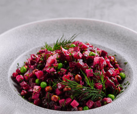Vibrant beetroot salad garnished with dill and peas served on a contemporary plateの写真素材