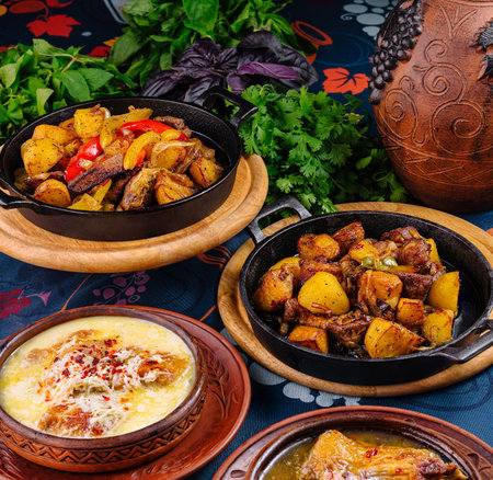 Aromatic and flavorful georgian cuisine dishes served in traditional earthenware crocks, showcasing a variety of meat and vegetable combinationsの写真素材