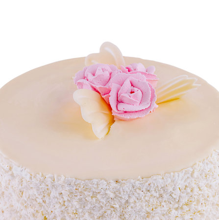 Delicious white chocolate birthday cake with coconut chips on a white backgroundの写真素材