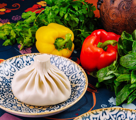 Steamed georgian dumpling khinkali served on a plate with fresh coriander, basil and bell peppersの写真素材