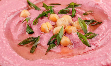 Close up of beetroot hummus garnished with fresh chives and chickpeasの写真素材