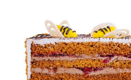 Delicious layered honey cake decorated with bees made of white and yellow chocolate on a white backgroundの写真素材