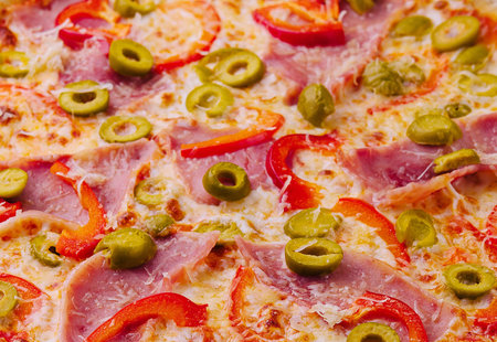 Top view of a savory pizza with green olives and tomatoes macro backgroundの写真素材