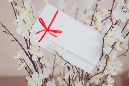 Gift card - closeup of a white card tied with a red ribbon.の写真素材