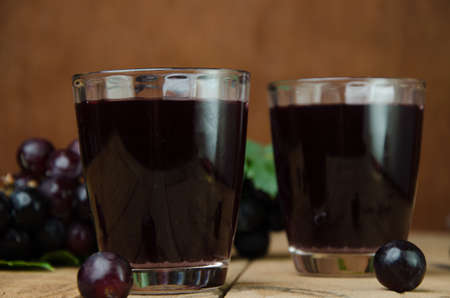 grapes juice and fruit on wooden background の写真素材