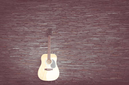 Wood guitar against wall ,background and textureの写真素材
