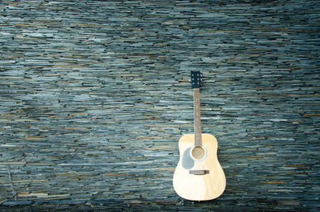 Wood guitar against wall ,background and textureの写真素材