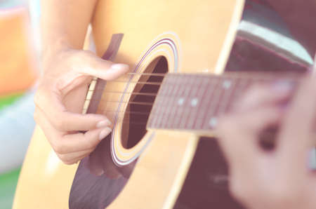 hands playing acoustic and classical guitar among the lightの写真素材