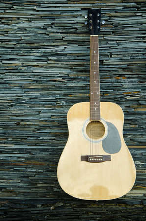 Wood guitar against wall ,background and textureの写真素材