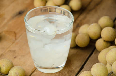 Longan juice and fresh longan on wooden background