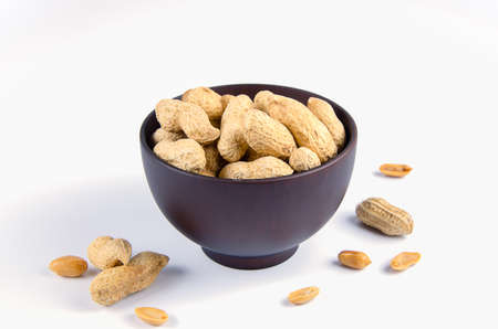 Peanuts in a wooden bowl on a separate background.