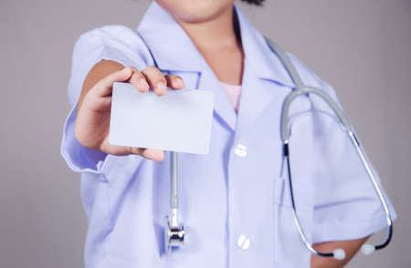 Doctor holding white business card on isolated backgroundの写真素材