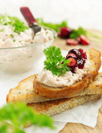 Crispy multigrain toasts with chicken cream, cranberry jam and parsleyの写真素材