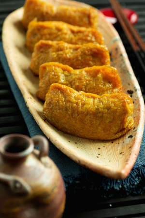 Japanese traditional type of sushi Inari-zushi, made from fried soy tofu wrapper and filled with sushi riceの写真素材