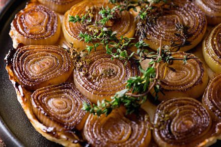 French traditional rustic onion Tarte tatin with balsamic vinegar, caramel and Provence herbsの写真素材