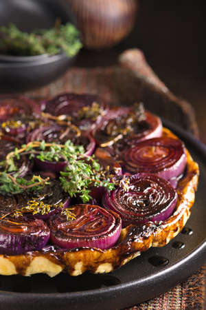 French traditional rustic onion Tarte tatin with balsamic vinegar, caramel and Provence herbsの写真素材