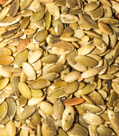 Close-up background texture of green roasted pumpkin seeds. Peeled pumpkin seeds background.の写真素材