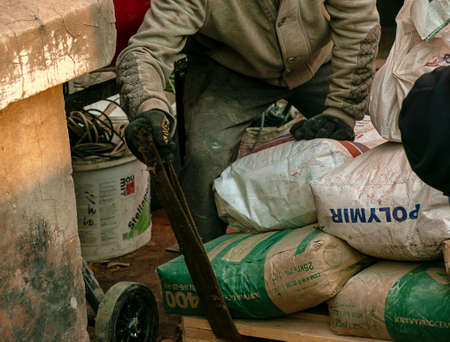 Dnepropetrovsk, Ukraine - 11.24.2021: Loading sandbags for the renovation of an apartment in a five-story building.のeditorial素材