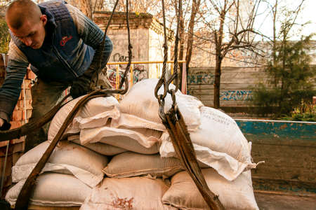 Dnepropetrovsk, Ukraine - 11.24.2021: Loading sandbags for the renovation of an apartment in a five-story building.のeditorial素材