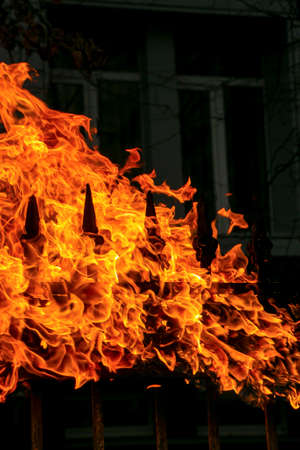 Metal fence on fire. The process of burning old paint on a metal structure using a gas burner.の写真素材