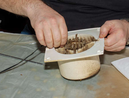 Close-up of a very dirty kitchen exhaust fan. Fan before preventive cleaning and washing. Disassembly process.の写真素材