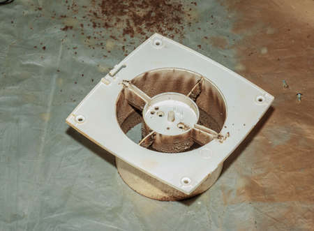 Close-up of a very dirty kitchen exhaust fan. Fan before preventive cleaning and washing. Dirty details.の写真素材