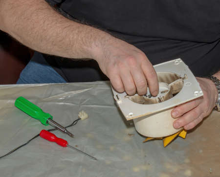 Close-up of a very dirty kitchen exhaust fan. Fan before preventive cleaning and washing. Disassembly process.の写真素材
