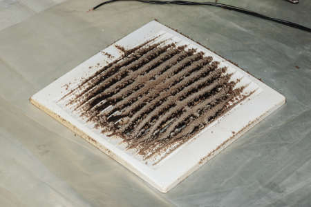 Close-up of a very dirty kitchen exhaust fan. Fan before preventive cleaning and washing. Dirty protective grill.の写真素材
